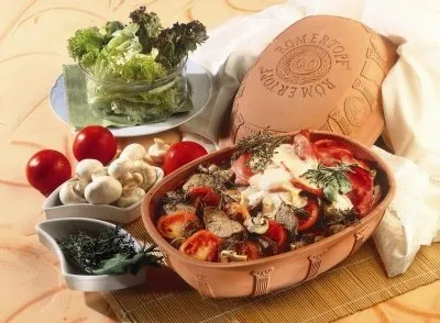 Römertopf Jubiläums-Bräter mittel mit Gemüse und Kräutern im Ofen